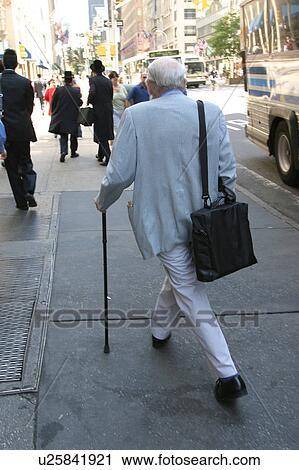 Man using a cane for walking stability on a city street. View Large Photo Image Stock Image - Man using a cane for walking stability on a city street.. Fotosearch