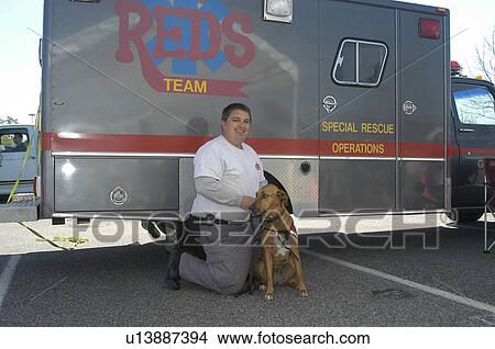 Picture - Man with service dog in front of Special Rescue Operations truck. Fotosearch