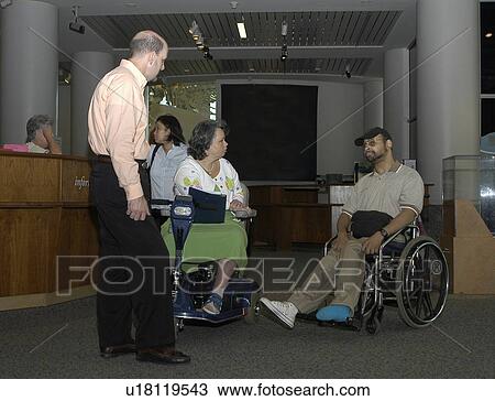Two people with disabilities conversing in a lobby area. View Large Photo Image Stock Image - Two people with disabilities conversing in a lobby area.. Fotosearch