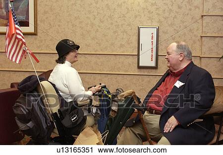 Two people with disabilities stopping to chat in the hall during a break at a conference. View Large Photo Image Stock Image - Two people with disabilities stopping to chat in the hall during a break at a conference.. Fotosearch