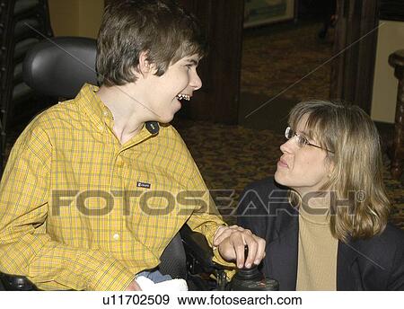 Young man with significant disabilities spending time with a friend. View Large Photo Image Stock Photo - Young man with significant disabilities spending time with a friend.. Fotosearch