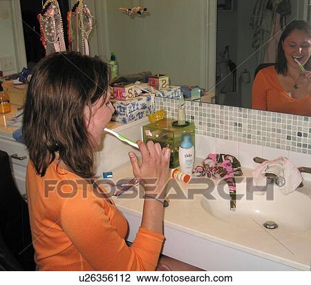 Young woman (wheelchair user) brushes her teeth in an accessible bathroom. View Large Photo Image Stock Image - Young woman (wheelchair user) brushes her teeth in an accessible bathroom.. Fotosearch