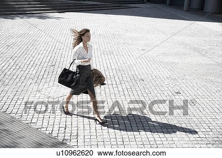 Businesswoman walking across public square (high angle view) View Large Photo Image Stock Image - Businesswoman walking across public square (high angle view). Fotosearch