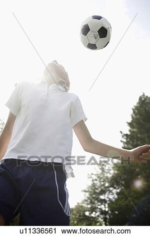 Girl (10-11) heading a soccer ball View Large Photo Image Stock Image - Girl (10-11) heading a soccer ball. Fotosearch