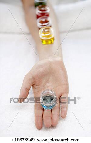 Stock Photo - Jars with liquid on woman's arm (close-up). Fotosearch