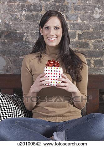 Stock Image - Mid-Adult Woman Holding Gift. Fotosearch