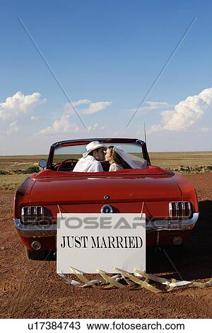 Newlyweds kissing in convertible View Large Photo Image Stock Image - Newlyweds kissing in convertible. Fotosearch