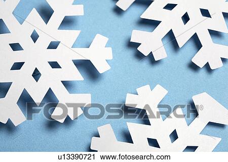 Stock Image - Paper snowflakes on blue background (close-up). Fotosearch