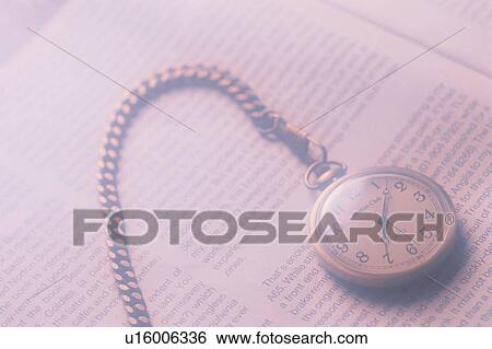 Stock Photograph - Pocket Watch On Text Page. Fotosearch