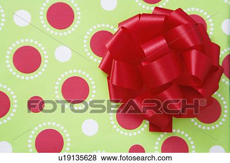 Stock Photo - Ribbon bow on wrapping paper (close-up). Fotosearch