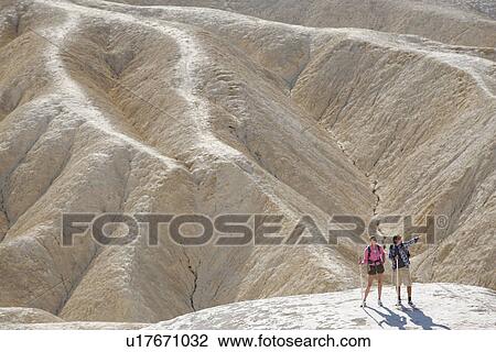 Stock Image - Two hikers in desert (high angle view), Death Valley, California, USA. Fotosearch