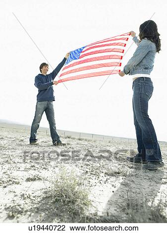 Stock Image - Woman and man holding Stars and Stripes. Fotosearch