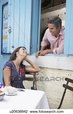 Stock Image - Woman talking to man at window. Fotosearch