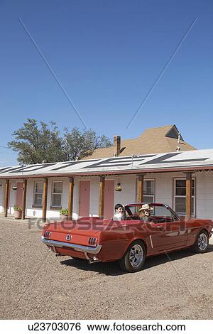 Stock Photograph - Young couple in convertible at motel, Arizona, USA. Fotosearch