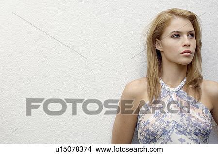 Young woman leaning on wall (portrait) View Large Photo Image Picture - Young woman leaning on wall (portrait). Fotosearch