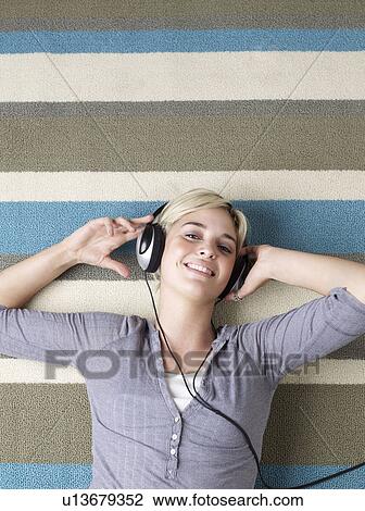 Stock Image - Young Woman Listening to Headphones. Fotosearch