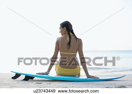 Young woman sitting on surfboard, St. John, US Virgin Islands, USA View Large Photo Image Stock Photo - Young woman sitting on surfboard, St. John, US Virgin Islands, USA. Fotosearch