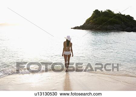 Young woman walking on sandy beach, St. John, US Virgin Islands, USA View Large Photo Image Stock Image - Young woman walking on sandy beach, St. John, US Virgin Islands, USA. Fotosearch