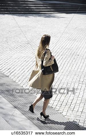 Stock Photo - Businesswoman walking down steps (high angle view). Fotosearch