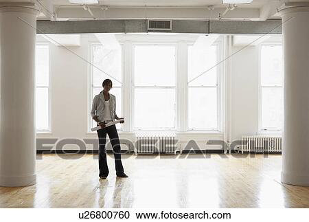 Stock Image - Female architect in empty room. Fotosearch