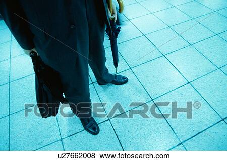 Stock Photo - Man Standing With Umbrella. Fotosearch