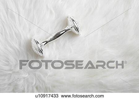Stock Image - Metallic rattle on sheepskin. Fotosearch
