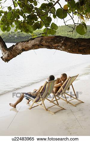 Mid adult couple on lounge chairs on beach (high angle view), St. John, US Virgin Islands, USA View Large Photo Image Stock Photography - Mid adult couple on lounge chairs on beach (high angle view), St. John, US Virgin Islands, USA. Fotosearch