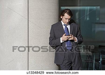 Stock Photo - Mid Adult Man Using Mobile Phone. Fotosearch