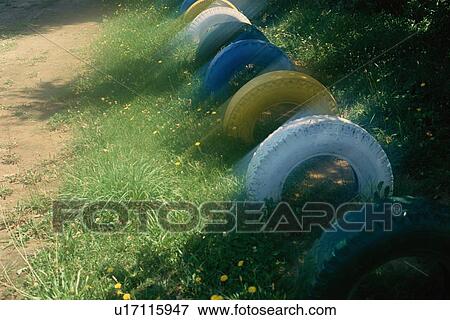 Stock Photo - Row Of Painted Tires In Grass. Fotosearch