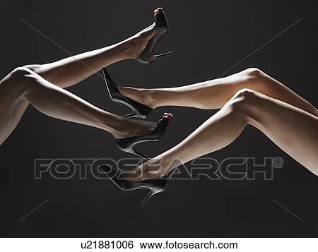 Stock Photograph - Two women wearing stilettos (low section). Fotosearch