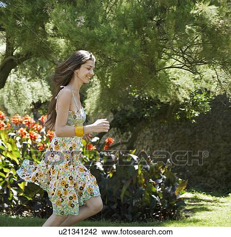 Stock Image - Two Young Women Running in Garden. Fotosearch