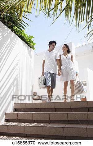 Young couple walking down steps with luggage View Large Photo Image Stock Image - Young couple walking down steps with luggage. Fotosearch