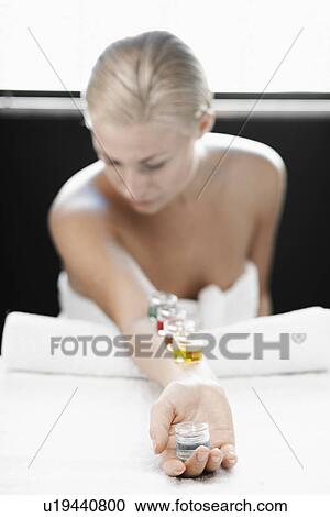 Stock Image - Young woman with liquids on arm. Fotosearch