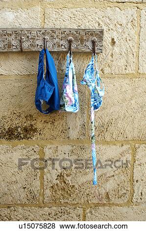Stock Photo - Bikini and Swimming Trunks Hanging on Hook. Fotosearch
