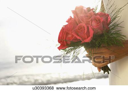 Bride holding bouquet (focus on flowers) View Large Photo Image Stock Photo - Bride holding bouquet (focus on flowers). Fotosearch