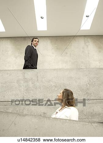 Stock Photo - Businesspeople walking on balcony (low angle view). Fotosearch