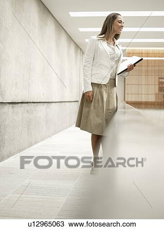Businesswoman with files looking over balcony (low angle view) View Large Photo Image Stock Image - Businesswoman with files looking over balcony (low angle view). Fotosearch