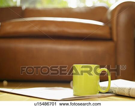 Mug and newspaper on floor near sofa View Large Photo Image Stock Image - Mug and newspaper on floor near sofa. Fotosearch