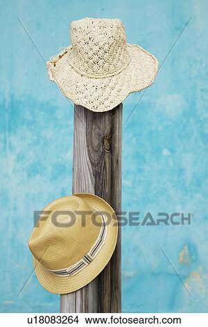 Picture - Two straw hats on pole. Fotosearch