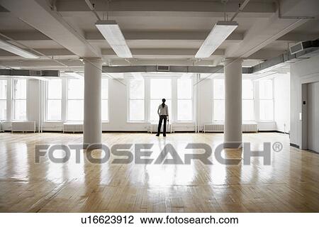 Woman looking through window in empty room View Large Photo Image Stock Image - Woman looking through window in empty room. Fotosearch