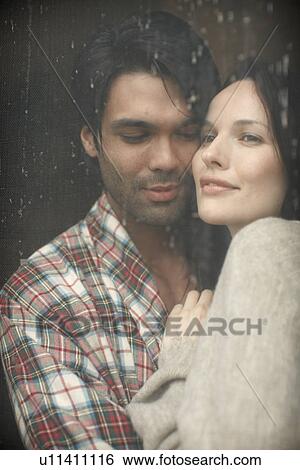 Young couple hugging by window with rain running down View Large Photo Image Stock Photograph - Young couple hugging by window with rain running down. Fotosearch