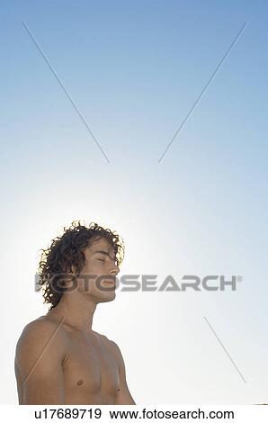 Young man against sky View Large Photo Image Stock Photo - Young man against sky. Fotosearch