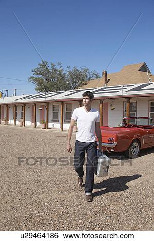 Young man arriving at motel, Arizona, USA View Large Photo Image Stock Photograph - Young man arriving at motel, Arizona, USA. Fotosearch