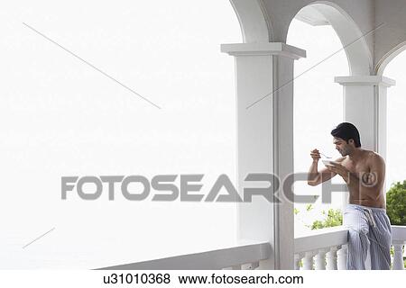 Young man eating breakfast on patio View Large Photo Image Stock Photo - Young man eating breakfast on patio. Fotosearch