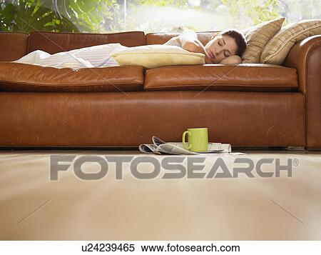 Young woman sleeping on sofa (low angle view) View Large Photo Image Stock Photography - Young woman sleeping on sofa (low angle view). Fotosearch