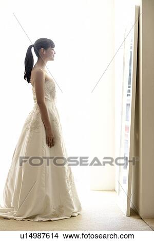 Young woman trying wedding dress on View Large Photo Image Picture - Young woman trying wedding dress on. Fotosearch