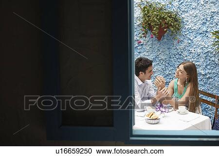 Couple holding hands in restaurant View Large Photo Image Stock Image - Couple holding hands in restaurant. Fotosearch