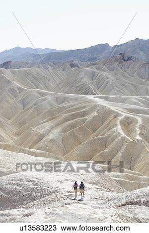 Stock Image - Couples hiking in rocky landscape, Death Valley, California, USA. Fotosearch