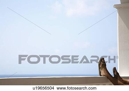 Picture - Man's feet on railing. Fotosearch
