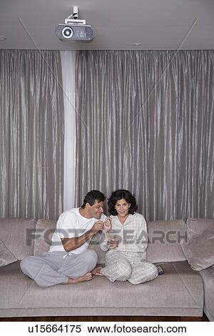 Mid adult couple eating ice cream and watching TV View Large Photo Image Stock Photography - Mid adult couple eating ice cream and watching TV. Fotosearch